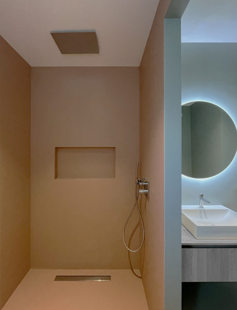 Cette image montre un WC et toilettes design en bois clair de taille moyenne avec un placard avec porte à panneau encastré, WC séparés, un carrelage vert, un mur rose, une vasque, un plan de toilette en bois, un sol rose, un plan de toilette beige, meuble-lavabo suspendu et un plafond décaissé.