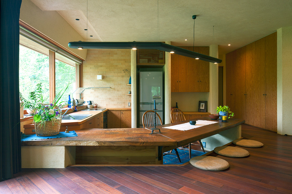This is an example of an asian l-shaped eat-in kitchen in Other with a drop-in sink and a peninsula.