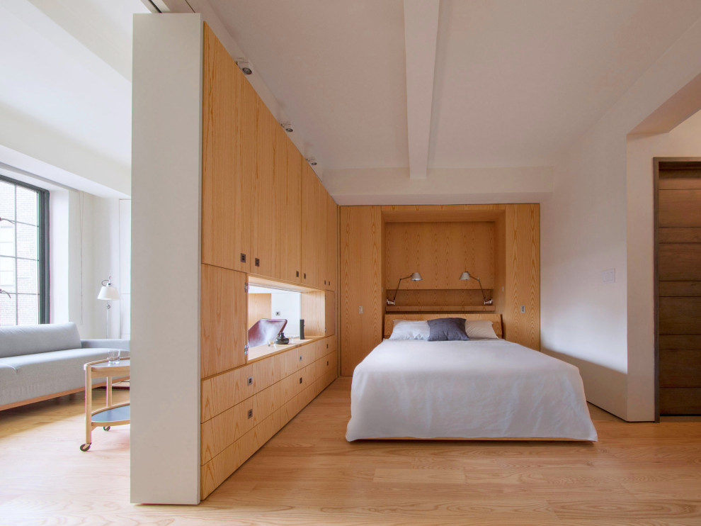 Esempio di una camera da letto minimalista con pareti bianche, pavimento in legno massello medio e pavimento marrone