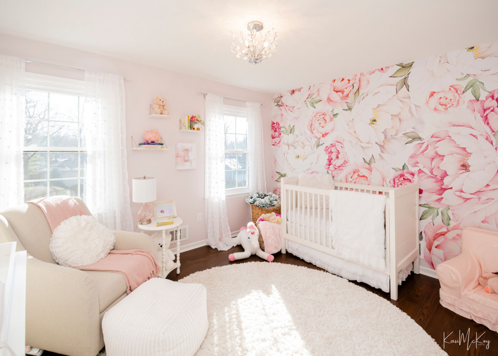 Idées déco pour une chambre de bébé fille classique de taille moyenne avec un mur rose, parquet foncé, un sol marron et du papier peint.