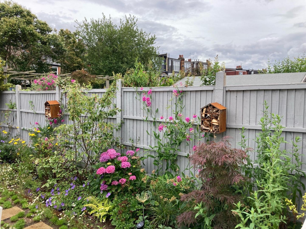 Mittelgroßer, Halbschattiger Industrial Garten hinter dem Haus, im Sommer mit Rasenkanten, Betonboden und Holzzaun in London