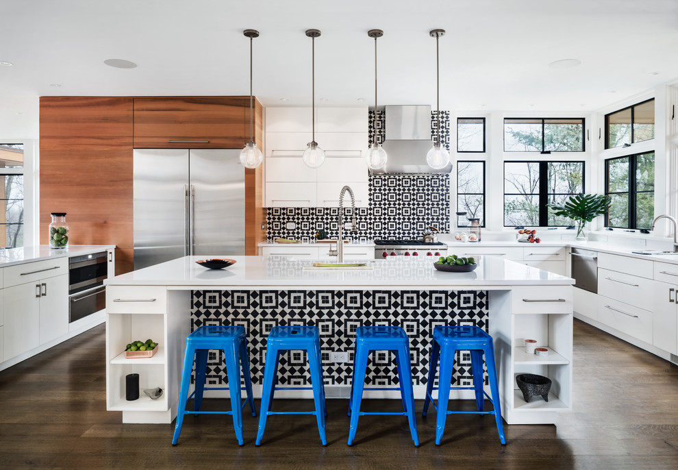 Inspiration for a modern u-shaped eat-in kitchen in New York with flat-panel cabinets, white cabinets, quartzite benchtops, multi-coloured splashback, cement tile splashback, stainless steel appliances, medium hardwood floors, with island, brown floor, an undermount sink and white benchtop.
