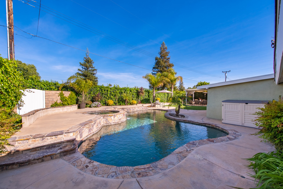 Mittelgroßer Landhaus Schwimmteich hinter dem Haus in Nierenform mit Pool-Gartenbau und Stempelbeton in Los Angeles