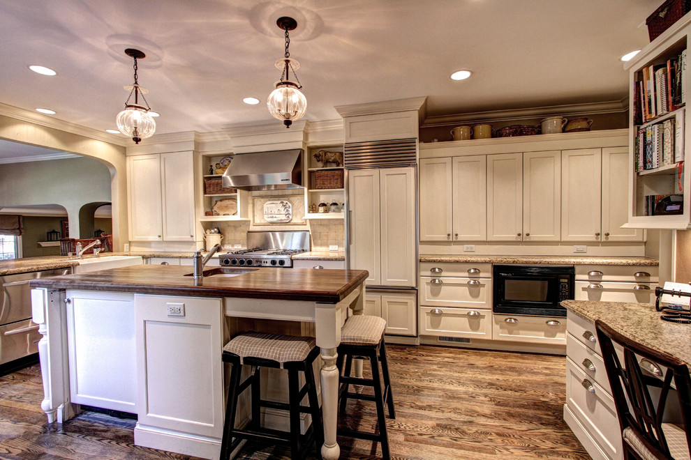 Inspiration for a large country l-shaped separate kitchen in Denver with a farmhouse sink, shaker cabinets, beige cabinets, granite benchtops, beige splashback, cement tile splashback, stainless steel appliances, dark hardwood floors, with island and brown floor.