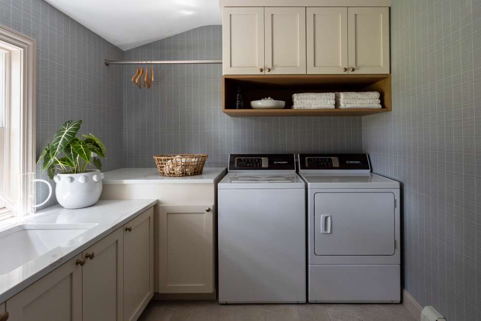 Inspiration for a french country l-shaped ceramic tile, beige floor and wallpaper dedicated laundry room remodel in Cleveland with an undermount sink, shaker cabinets, beige cabinets, blue walls, a side-by-side washer/dryer and white countertops