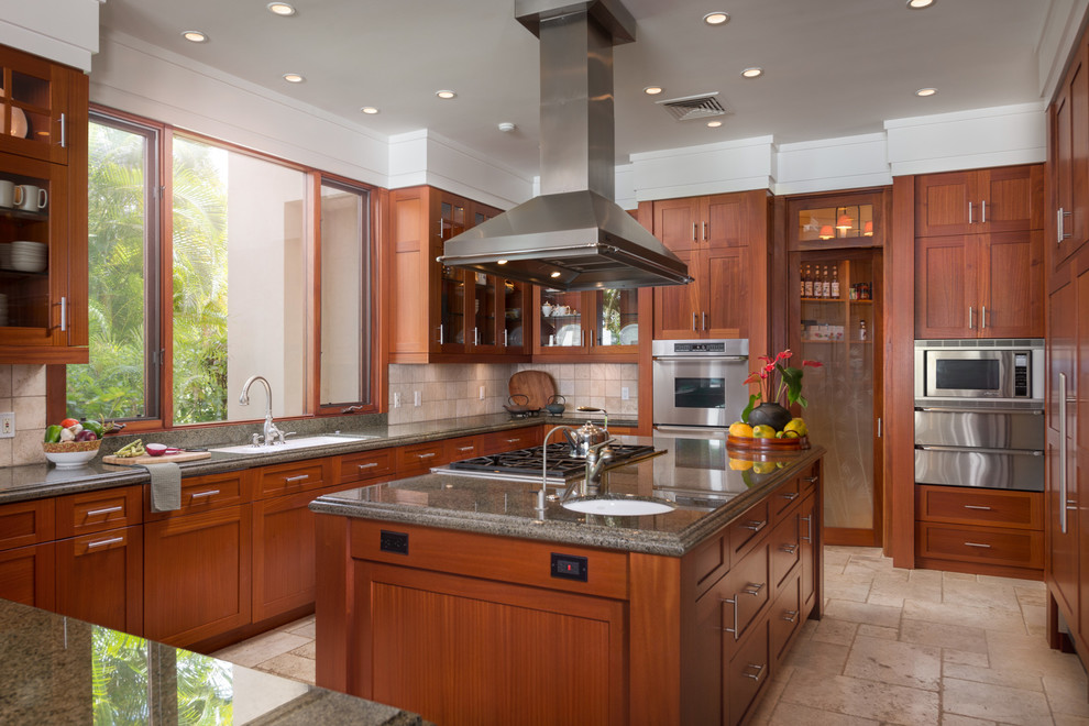 Inspiration for a traditional kitchen in Orange County with an undermount sink, glass-front cabinets, medium wood cabinets, beige splashback, stainless steel appliances and with island.