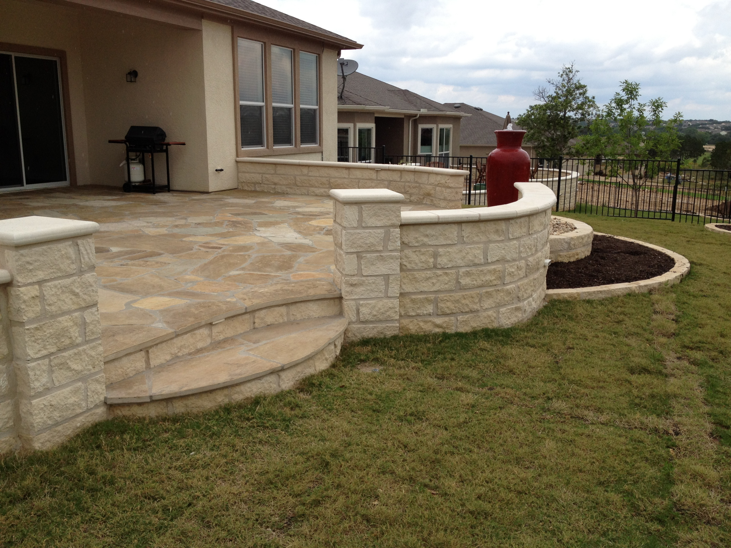 Flagstone patio with limestone seatwalls & pondless water feature