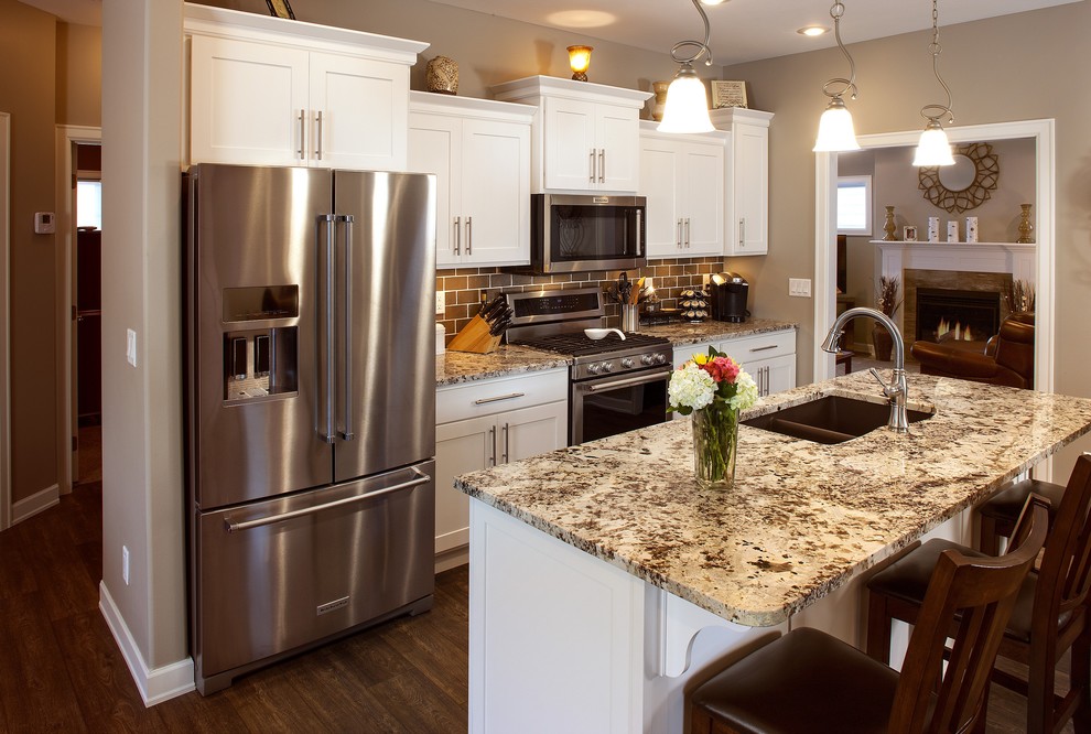 Kitchen - small single-wall kitchen idea with flat-panel cabinets, white cabinets, stainless steel appliances and an island