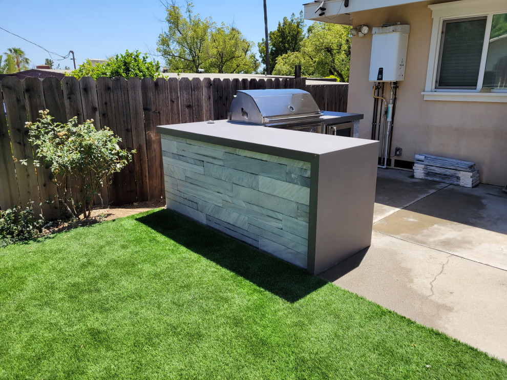 Réalisation d'une terrasse arrière minimaliste avec une cuisine d'été.