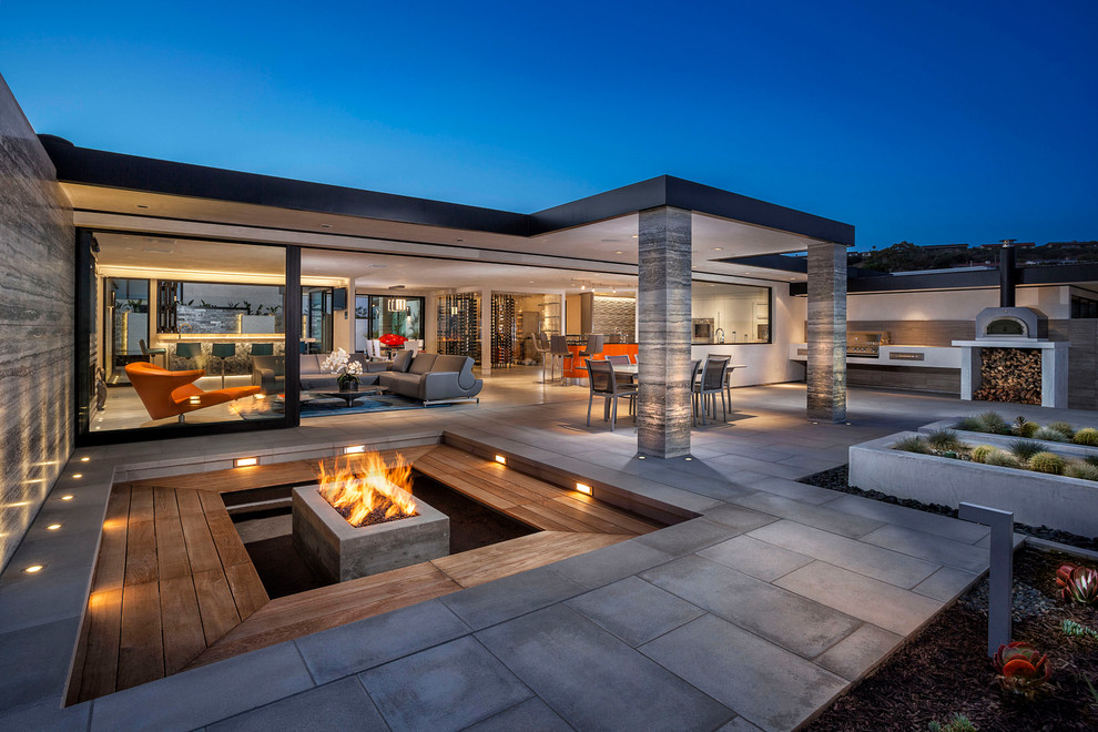 Photo of an expansive contemporary patio in Orange County with a fire feature and no cover.