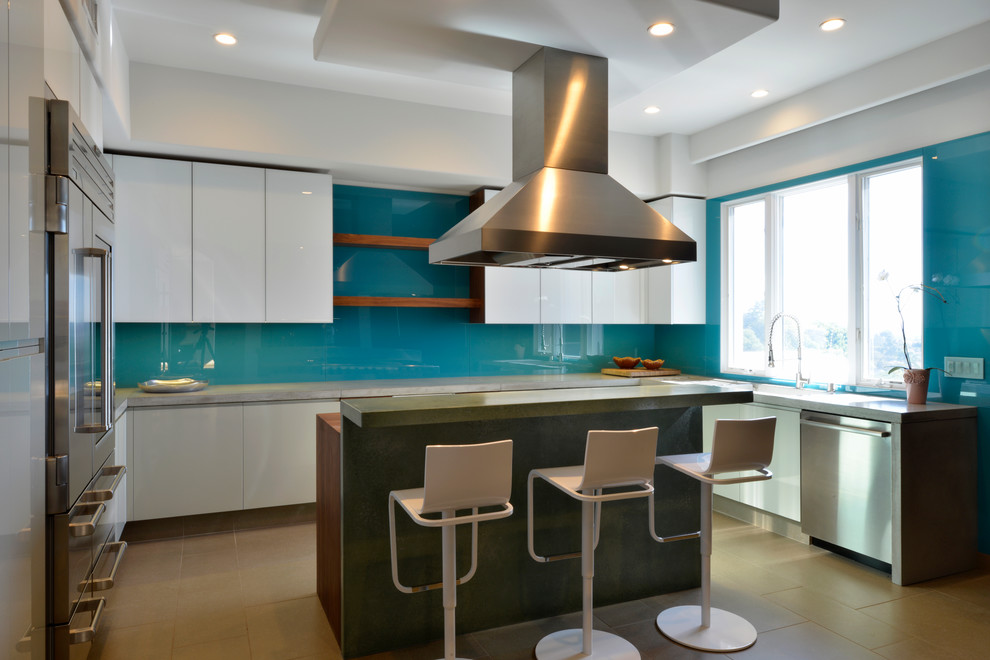 Photo of a mid-sized contemporary l-shaped eat-in kitchen in San Diego with flat-panel cabinets, white cabinets, concrete benchtops, blue splashback, stainless steel appliances, with island, an integrated sink and glass sheet splashback.