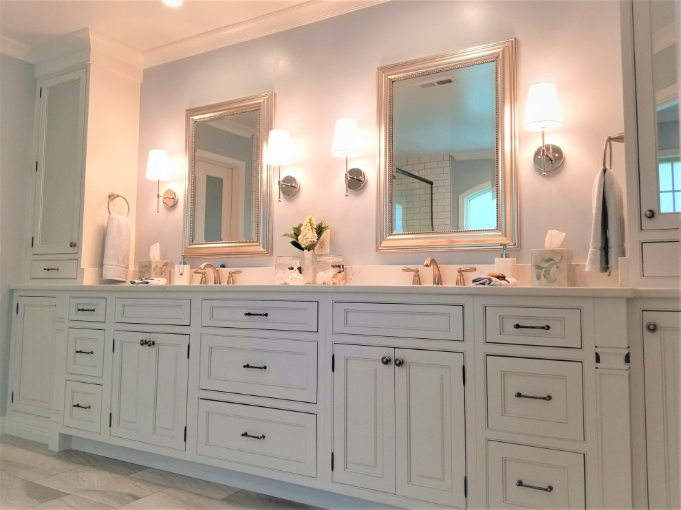 Пример оригинального дизайна: большая главная ванная комната в классическом стиле с фасадами с выступающей филенкой, белыми фасадами, отдельно стоящей ванной, угловым душем, белой плиткой, керамогранитной плиткой, полом из керамогранита, врезной раковиной, столешницей из искусственного кварца, серым полом, душем с распашными дверями, белой столешницей, сиденьем для душа, тумбой под две раковины и встроенной тумбой