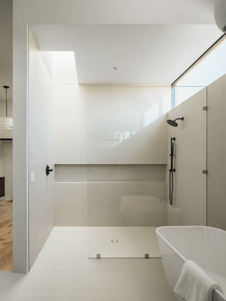 Photo of a large modern ensuite bathroom in Phoenix with flat-panel cabinets, dark wood cabinets, a freestanding bath, a built-in shower, a two-piece toilet, beige tiles, porcelain tiles, white walls, porcelain flooring, a submerged sink, engineered stone worktops, beige floors, an open shower, white worktops, an enclosed toilet, double sinks and a floating vanity unit.