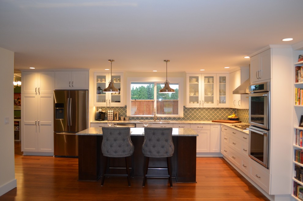 Inspiration for a large transitional l-shaped open plan kitchen in Seattle with shaker cabinets, white cabinets, quartzite benchtops, blue splashback, glass tile splashback, stainless steel appliances, bamboo floors, with island, an undermount sink and brown floor.