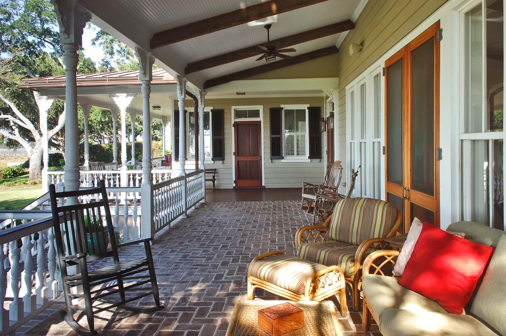 Design ideas for a traditional verandah in Charleston with brick pavers and a roof extension.