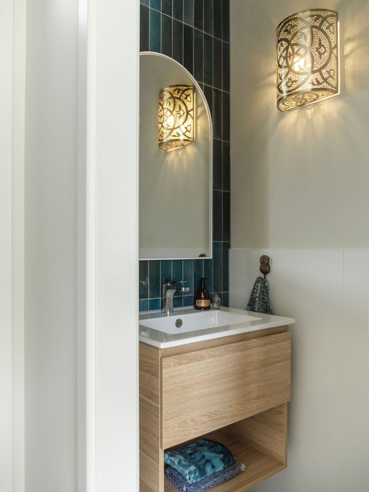 Inspiration for a small contemporary powder room in Melbourne with light wood cabinets, a one-piece toilet, blue tile, ceramic tile, white walls, concrete floors, an integrated sink, grey floor, white benchtops and a floating vanity.