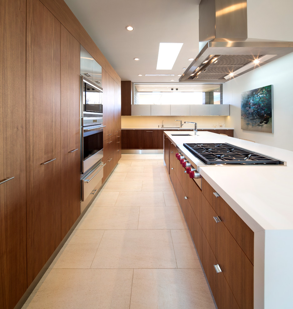 This is an example of a contemporary l-shaped open plan kitchen in Phoenix with flat-panel cabinets, medium wood cabinets, stainless steel appliances and an undermount sink.