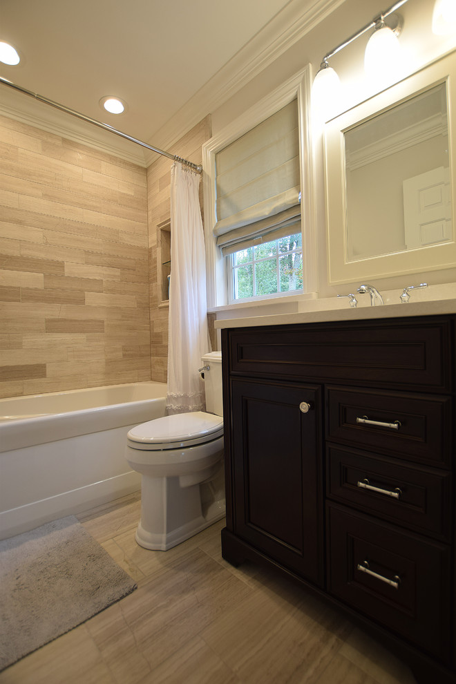 Design ideas for a small traditional kids bathroom in New York with raised-panel cabinets, dark wood cabinets, an alcove tub, a shower/bathtub combo, a two-piece toilet, gray tile, limestone, grey walls, limestone floors, an undermount sink, engineered quartz benchtops, grey floor and a shower curtain.