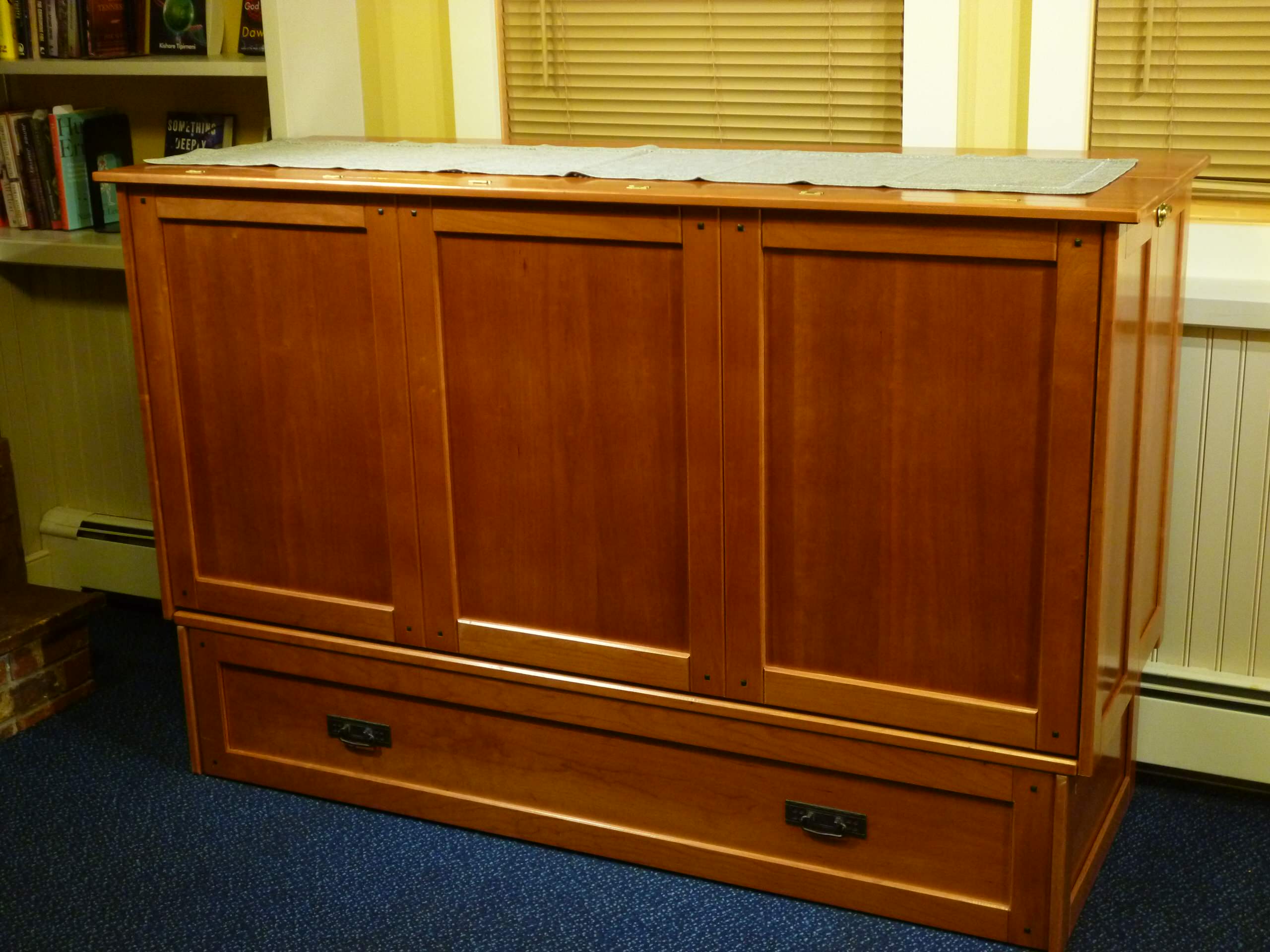 Cabinet bed- closed.  Converts to queen size bed. In cherry hardwood.