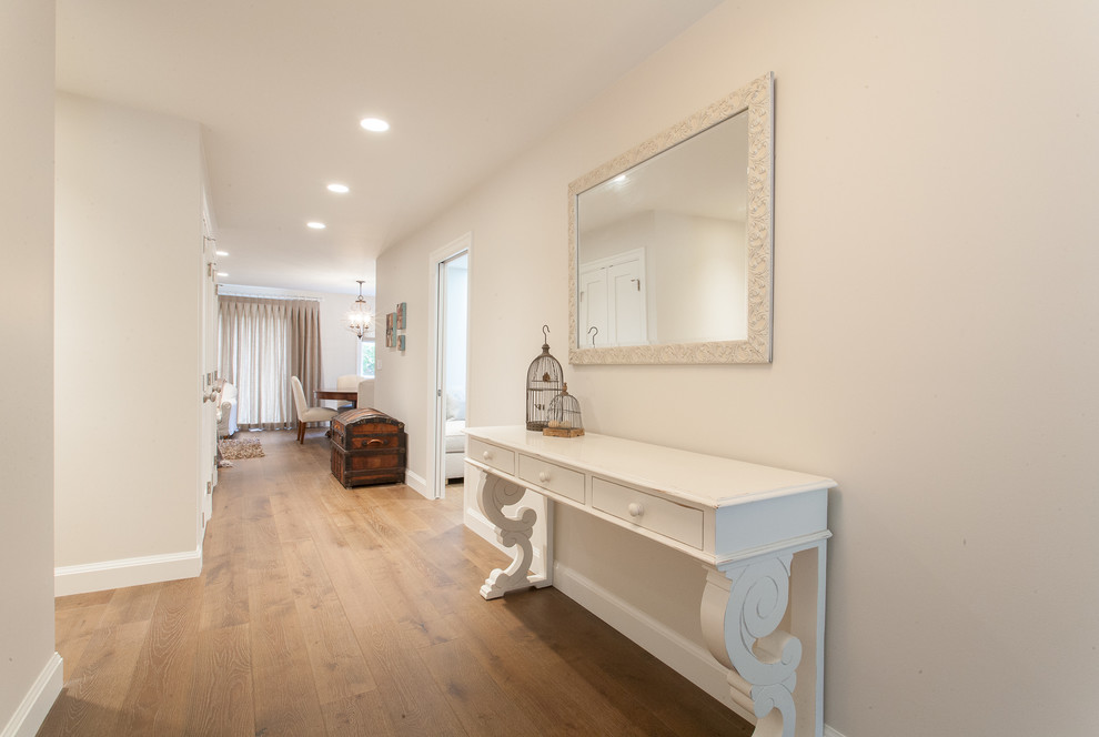 This is an example of a mid-sized traditional hallway in Vancouver with white walls and medium hardwood floors.