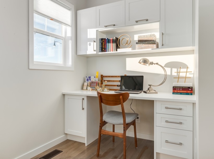 Inspiration for a small contemporary study in Calgary with white walls, medium hardwood flooring and a built-in desk.
