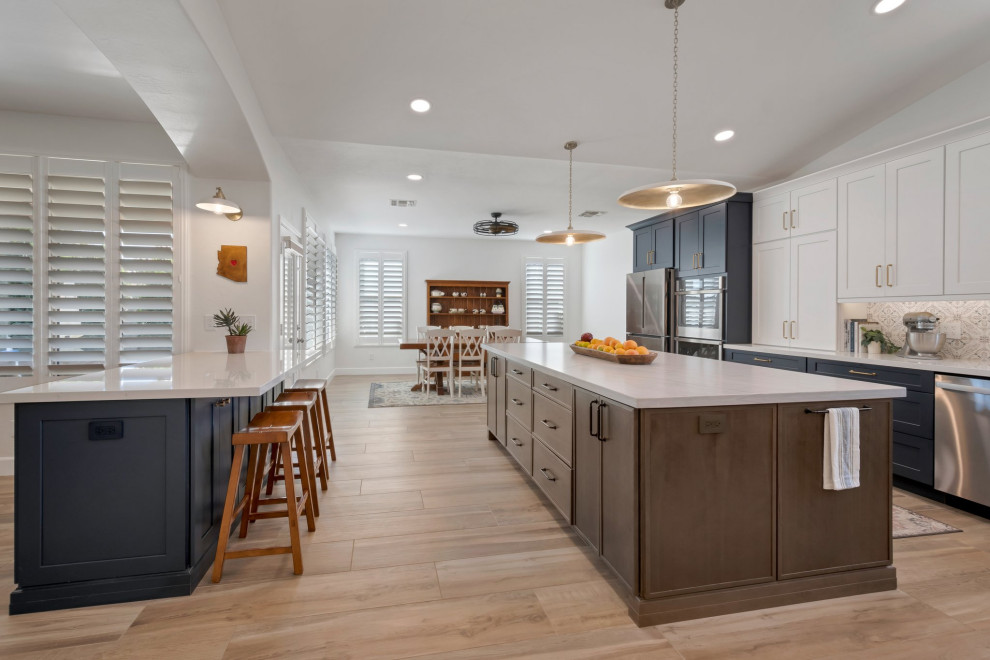 Eat-in kitchen - large transitional l-shaped porcelain tile, brown floor and vaulted ceiling eat-in kitchen idea in Phoenix with an undermount sink, shaker cabinets, blue cabinets, quartzite countertops, multicolored backsplash, mosaic tile backsplash, stainless steel appliances, two islands and white countertops