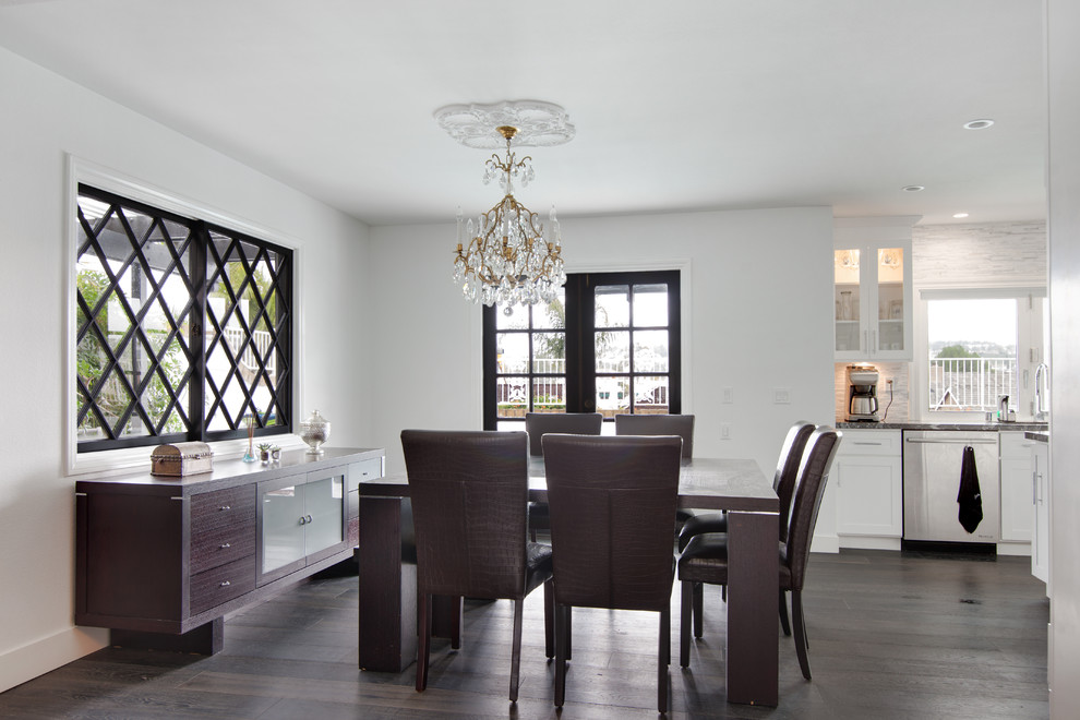 Inspiration for a large modern dining room in Orange County with white walls, dark hardwood floors, a hanging fireplace and a stone fireplace surround.