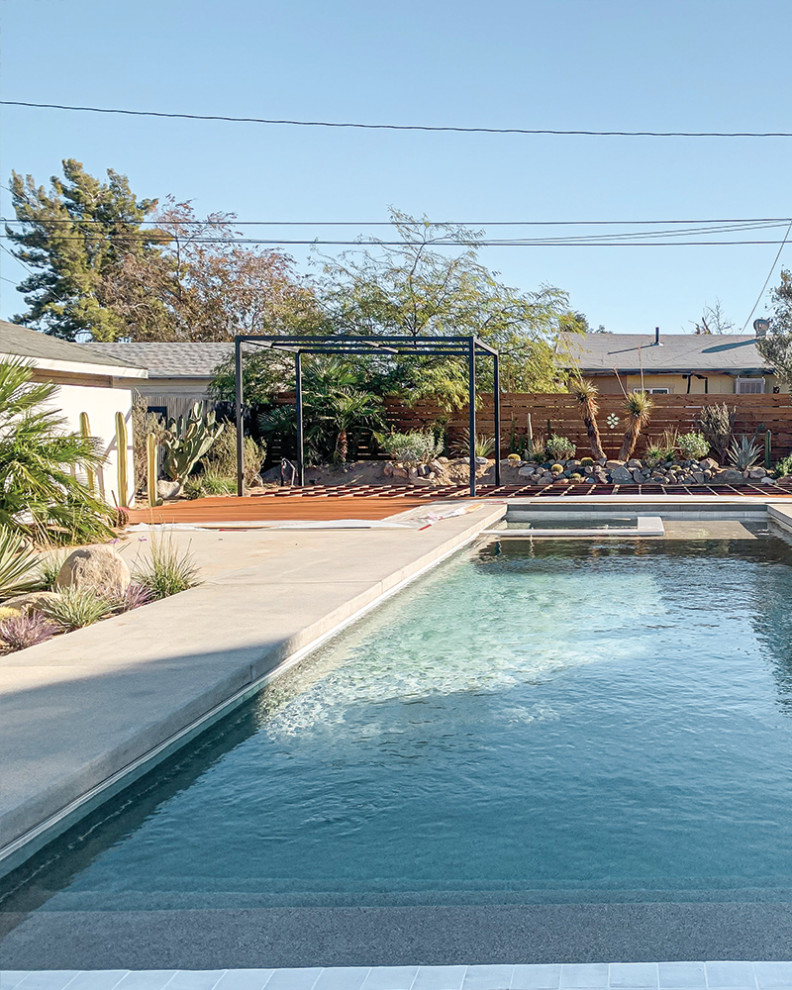 Bild på en medelhavsstil rektangulär pool på baksidan av huset, med spabad och trädäck