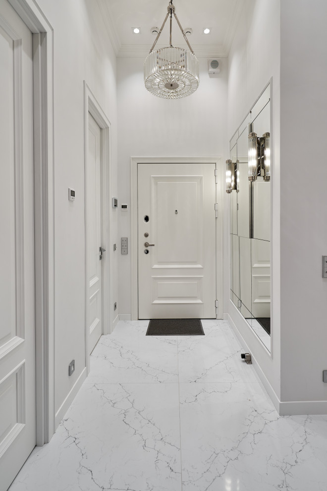На фото: прихожая среднего размера: освещение в стиле неоклассика (современная классика) с белыми стенами, мраморным полом, одностворчатой входной дверью, белой входной дверью и белым полом