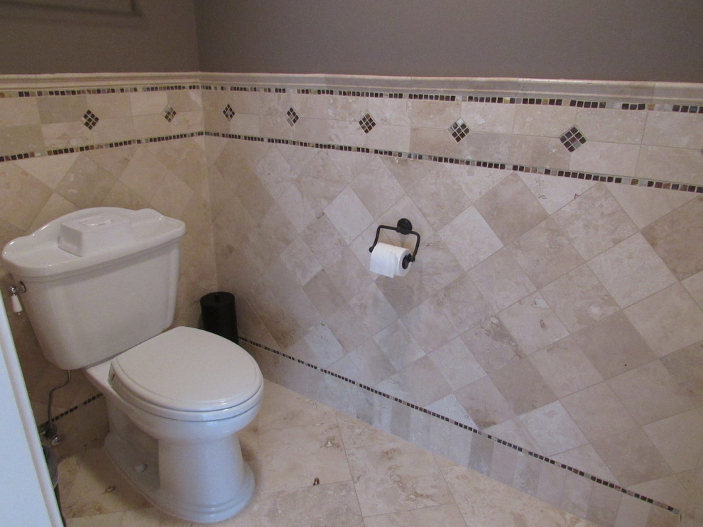 Mid-sized traditional master bathroom in New York with raised-panel cabinets, dark wood cabinets, a drop-in tub, an open shower, a one-piece toilet, beige tile, brown tile, porcelain tile, multi-coloured walls, travertine floors, an undermount sink and granite benchtops.