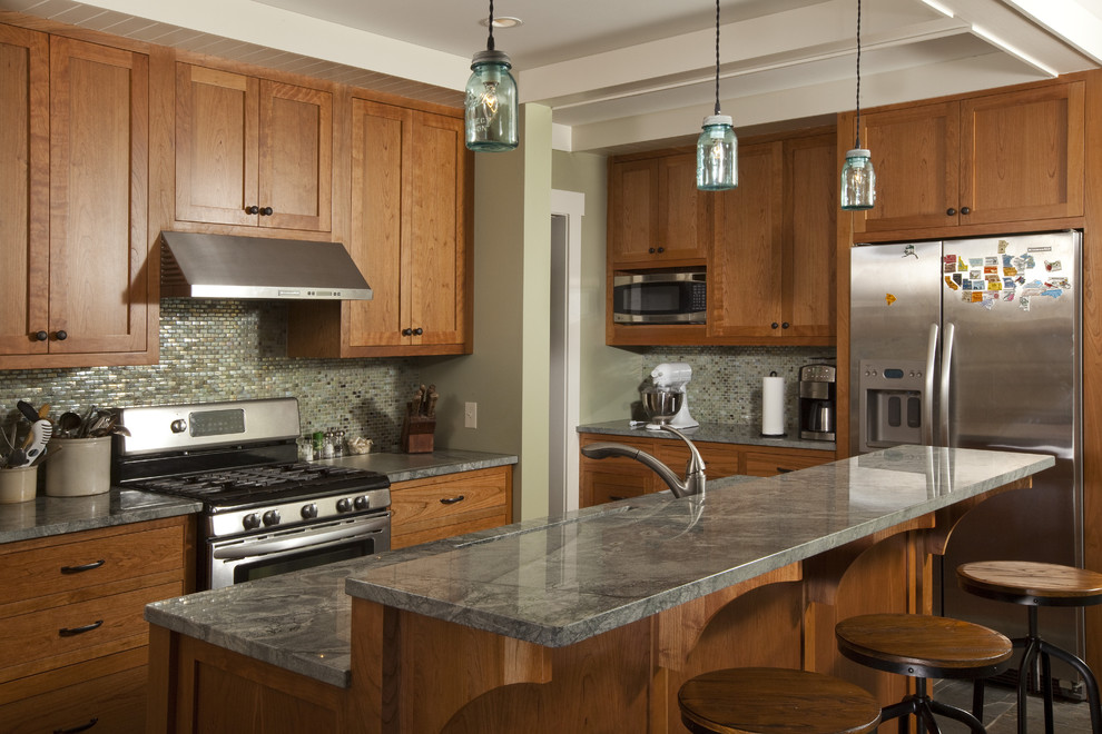Photo of a traditional kitchen in Minneapolis with mosaic tile splashback, stainless steel appliances, green splashback, shaker cabinets, medium wood cabinets and granite benchtops.