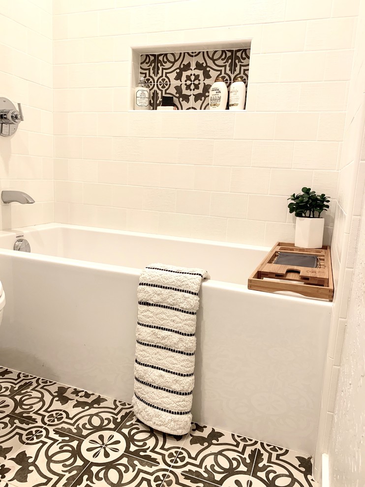 This is an example of a small contemporary kids bathroom in San Francisco with a drop-in tub, a shower/bathtub combo, a two-piece toilet, white tile, ceramic tile, grey walls, cement tiles, an undermount sink, marble benchtops, multi-coloured floor, a shower curtain and grey benchtops.