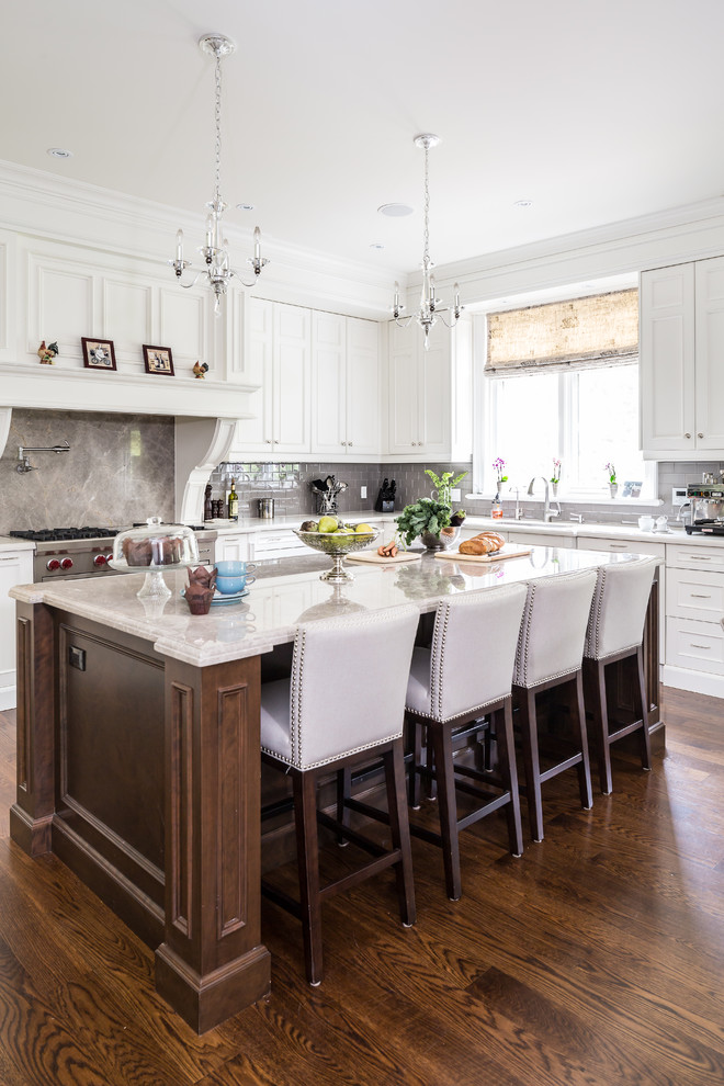 This is an example of a traditional kitchen in Toronto with white cabinets, grey splashback and dark hardwood floors.