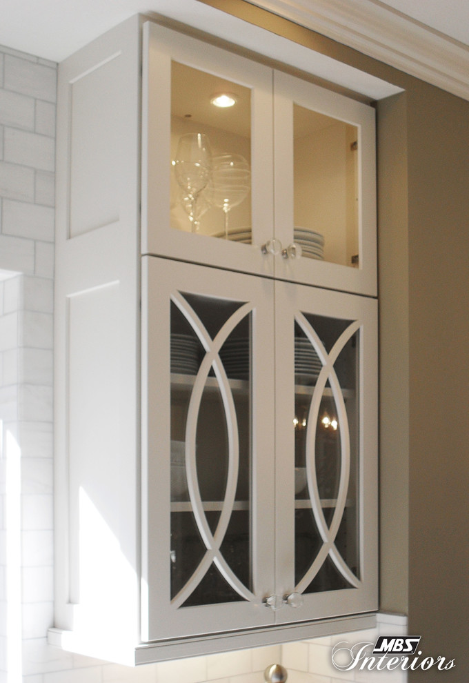Inspiration for a mid-sized transitional u-shaped medium tone wood floor eat-in kitchen remodel with a farmhouse sink, shaker cabinets, white cabinets, quartzite countertops, white backsplash, subway tile backsplash, stainless steel appliances and an island