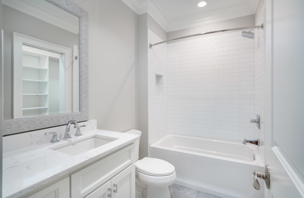 Inspiration for a mid-sized transitional 3/4 bathroom in Other with shaker cabinets, white cabinets, an alcove tub, a shower/bathtub combo, a two-piece toilet, white tile, subway tile, grey walls, marble floors, an undermount sink, marble benchtops, grey floor and a shower curtain.