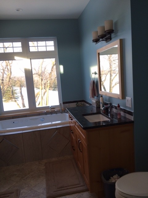 Drop-in bathtub - rustic master beige tile and ceramic tile ceramic tile drop-in bathtub idea with shaker cabinets, medium tone wood cabinets, a one-piece toilet, blue walls, quartz countertops and an undermount sink