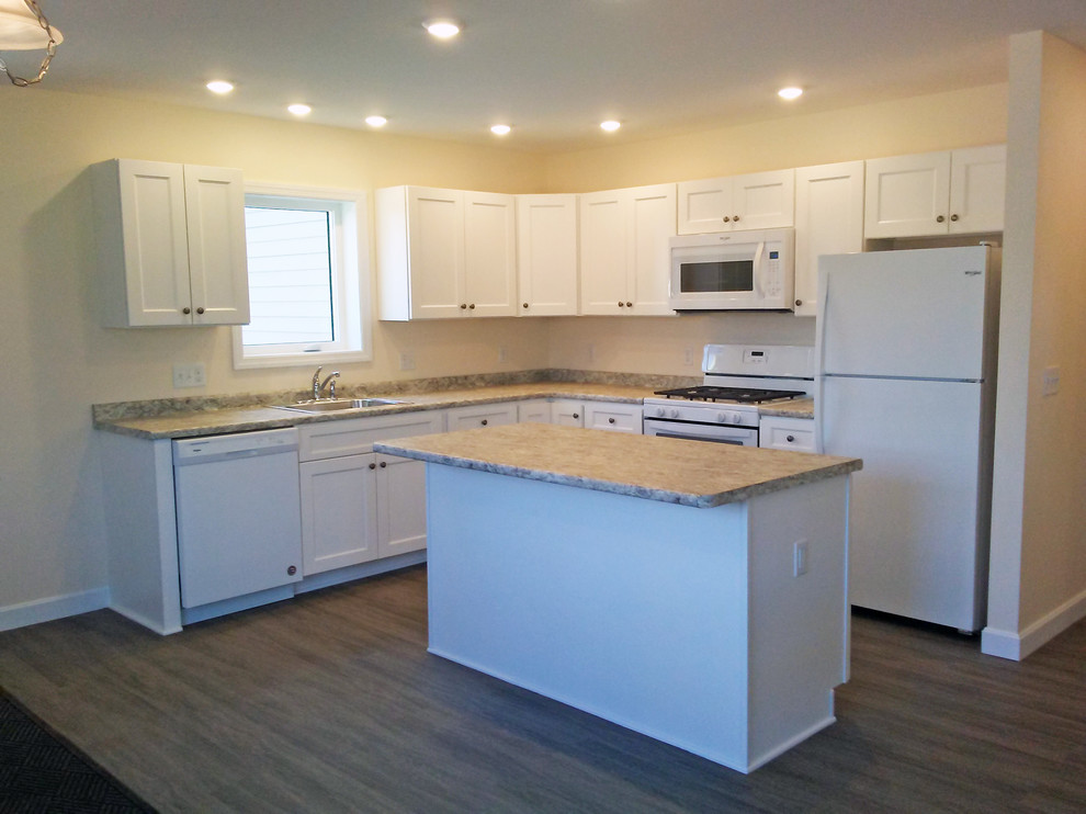 Kitchen pantry - mid-sized transitional l-shaped vinyl floor and gray floor kitchen pantry idea with a drop-in sink, recessed-panel cabinets, white cabinets, laminate countertops, white appliances, an island and beige countertops