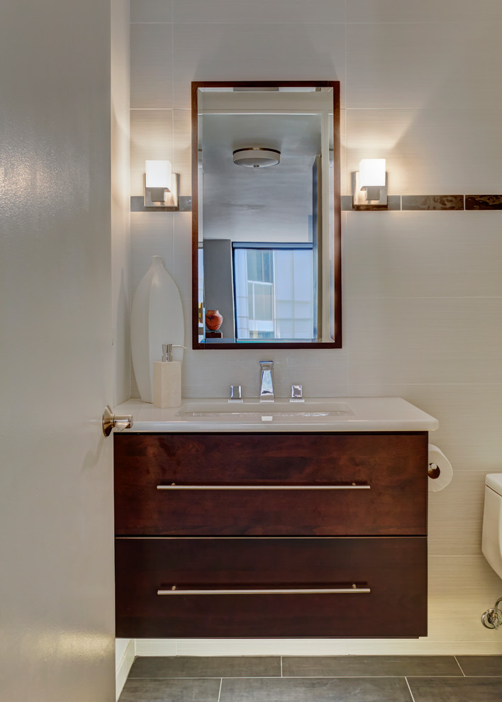 Small modern 3/4 bathroom in Chicago with flat-panel cabinets, dark wood cabinets, an alcove tub, a shower/bathtub combo, a one-piece toilet, white tile, porcelain tile, white walls, porcelain floors, an undermount sink and engineered quartz benchtops.