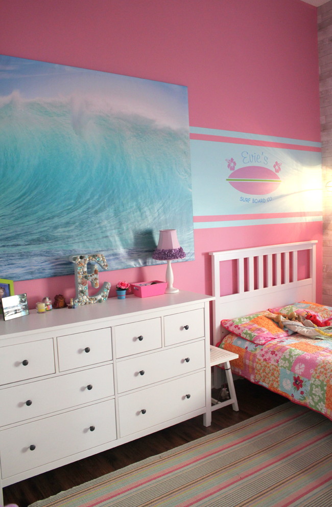 Mid-sized beach style kids' bedroom in New Orleans with pink walls and medium hardwood floors for kids 4-10 years old and girls.