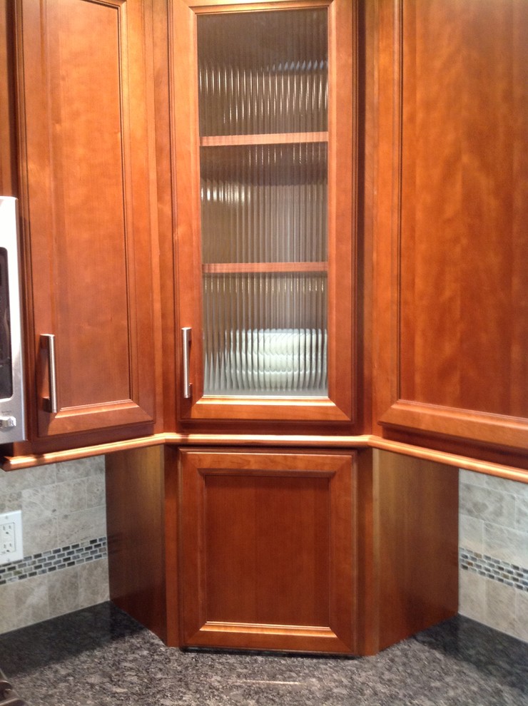 Eat-in kitchen - mid-sized transitional l-shaped medium tone wood floor eat-in kitchen idea with an undermount sink, recessed-panel cabinets, medium tone wood cabinets, granite countertops, gray backsplash, stone tile backsplash, stainless steel appliances, gray walls and an island