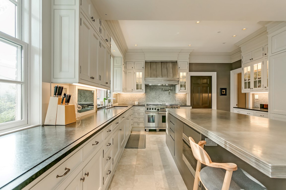 Design ideas for an expansive transitional u-shaped eat-in kitchen in Toronto with an undermount sink, raised-panel cabinets, grey cabinets, soapstone benchtops, grey splashback, marble splashback, stainless steel appliances, marble floors, with island, beige floor and black benchtop.