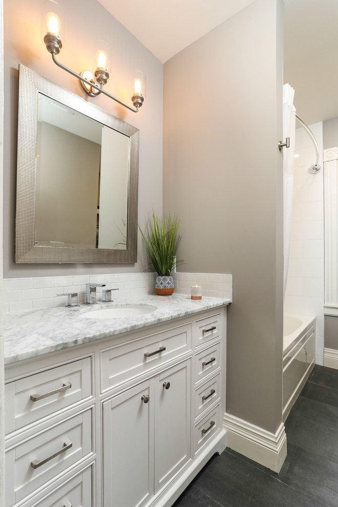 Alcove bathtub - mid-sized transitional white tile gray floor alcove bathtub idea with shaker cabinets, white cabinets, a one-piece toilet, gray walls, an undermount sink and gray countertops