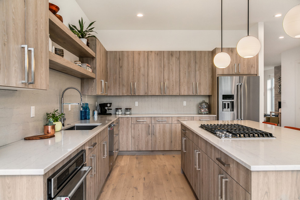 Design ideas for a contemporary u-shaped eat-in kitchen in Seattle with an undermount sink, flat-panel cabinets, medium wood cabinets, beige splashback, stainless steel appliances, medium hardwood floors, with island, brown floor and beige benchtop.
