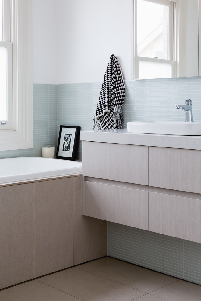 This is an example of a mid-sized modern master bathroom in Melbourne with grey cabinets, blue tile, glass tile and white walls.