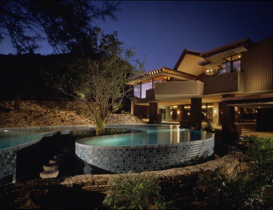 Example of a large minimalist backyard custom-shaped and stone infinity pool design in Phoenix