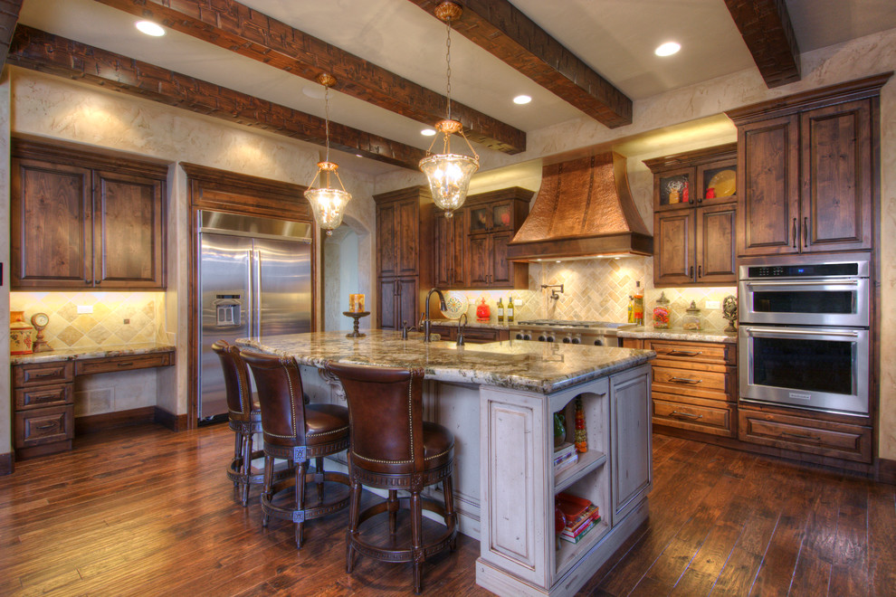 Photo of a large traditional l-shaped eat-in kitchen in Denver with raised-panel cabinets, dark wood cabinets, multi-coloured splashback, stainless steel appliances and with island.