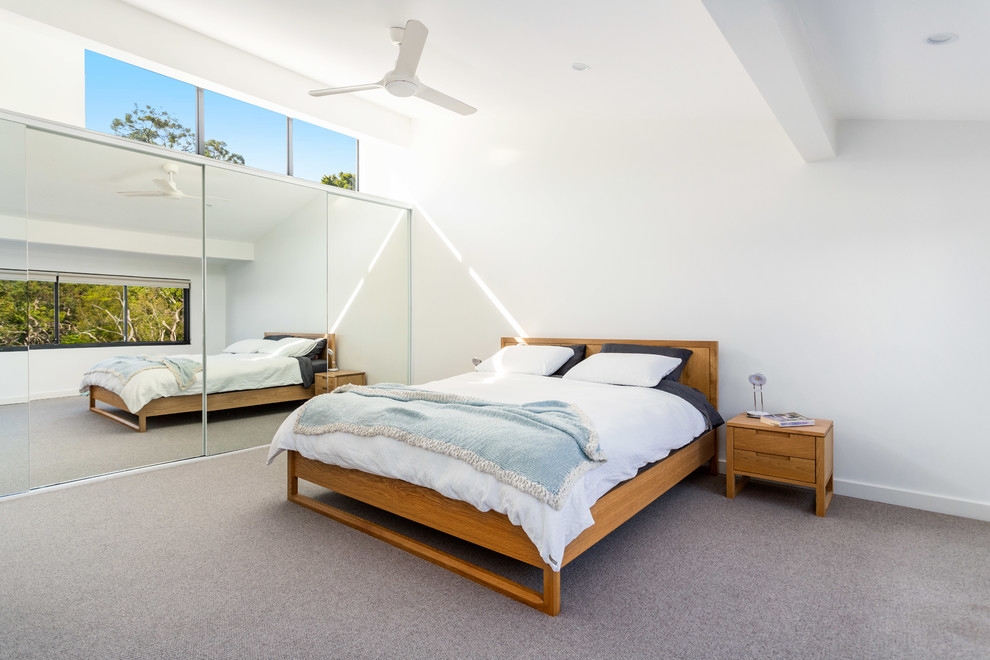 Contemporary master bedroom in Sydney with carpet, white walls and grey floor.