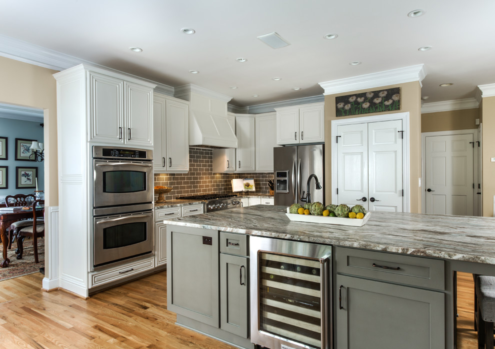 This is an example of a traditional l-shaped kitchen in Charlotte with beaded inset cabinets, white cabinets, brown splashback, subway tile splashback, stainless steel appliances, medium hardwood floors and with island.