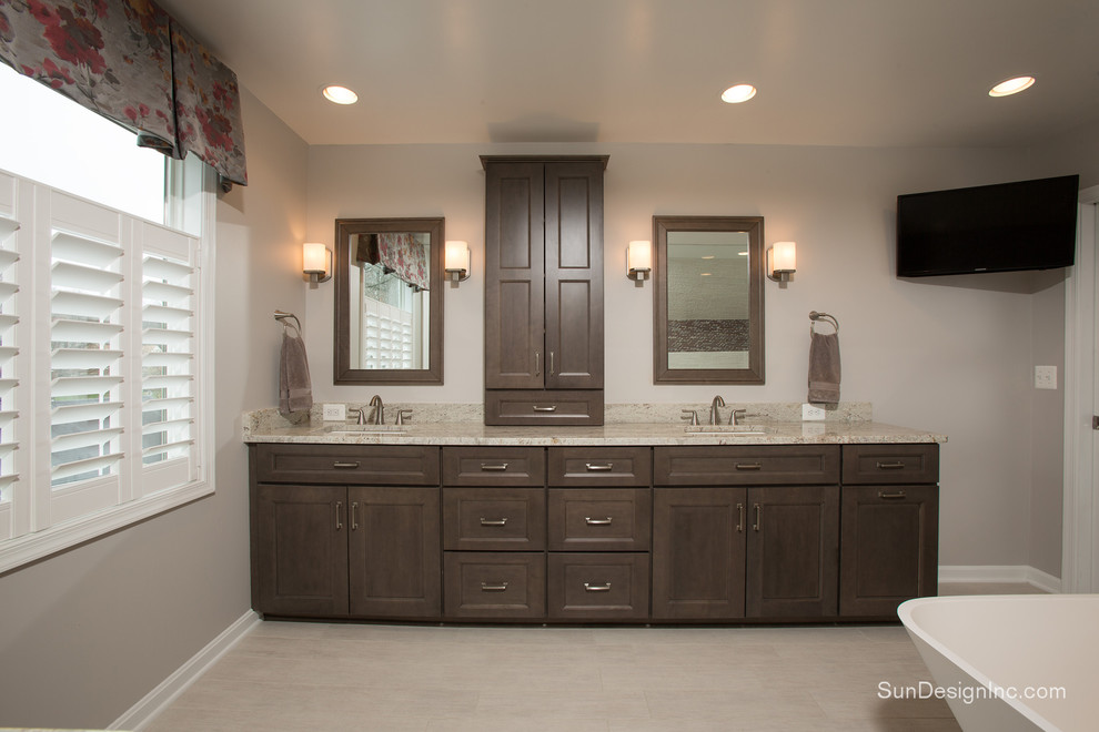 This is an example of a transitional master bathroom in DC Metro with an undermount sink, shaker cabinets, dark wood cabinets, granite benchtops, a freestanding tub, an open shower, white tile, ceramic tile, white walls and ceramic floors.