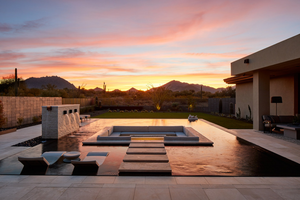 Mittelgroßer, Gefliester Infinity-Pool hinter dem Haus in rechteckiger Form mit Wasserspiel in Phoenix
